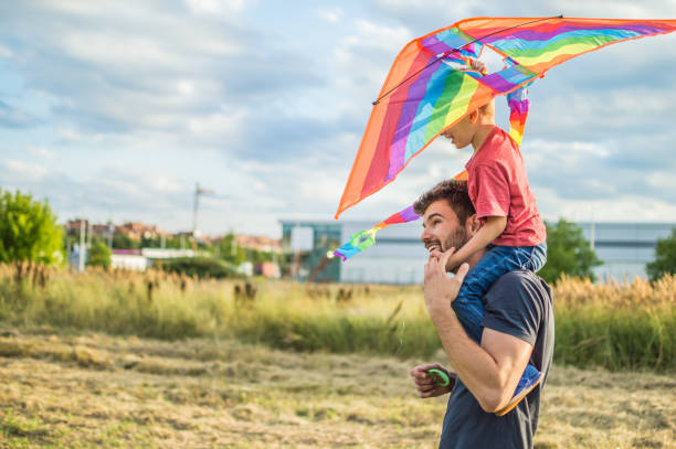 istock Little boy flying a kite with his father 1001289150