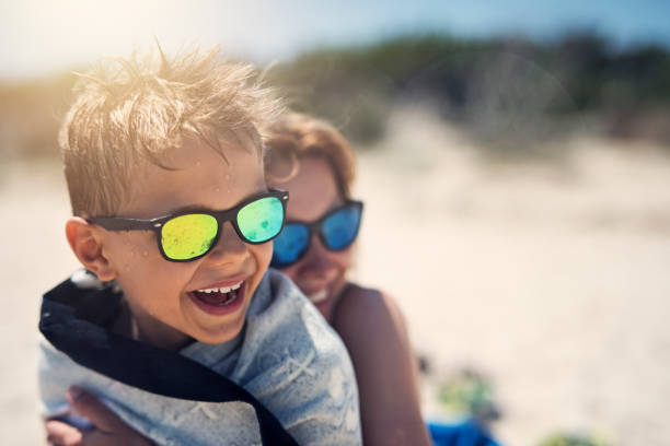 Mother and son hugging and laughing on beach