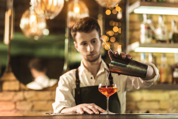 istock Pleasant young barman mixing a cocktail 1001308010