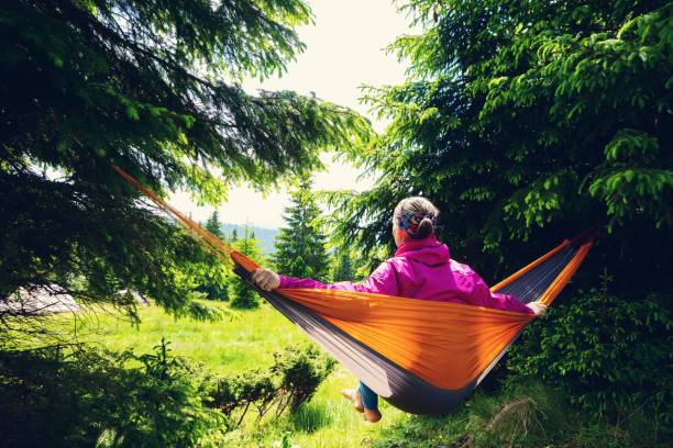 istock Adventurer female relaxes in hammock 1001316324