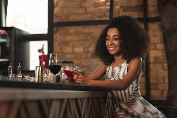 istock Petite curly woman smiling after receiving message 1001321402