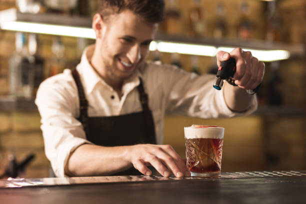 istock Upbeat young barman burning sugar with culinary torch 1001321772