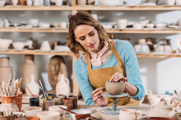 istock beautiful female potter decorating ceramic bowl in workshop 1001334868