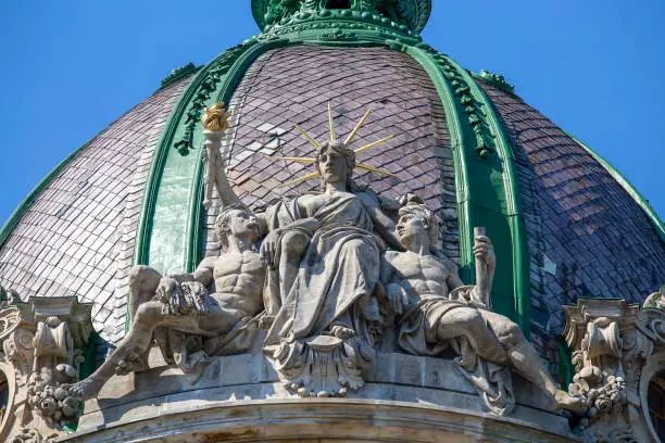 Sculptural composition with sitting Statue of Liberty at the dome of the old house in Lviv, Ukraine. Close up