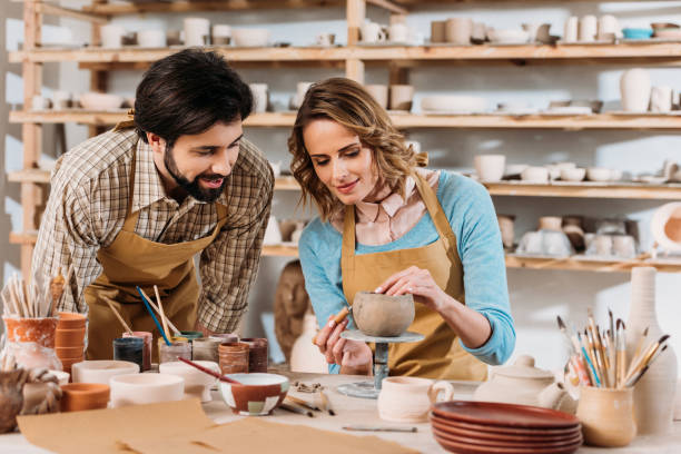 istock couple of potters decorating ceramic bowl in workshop 1001336002