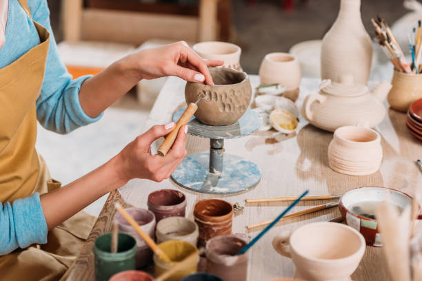 istock cropped view of female potter decorating ceramic bowl in workshop 1001336088