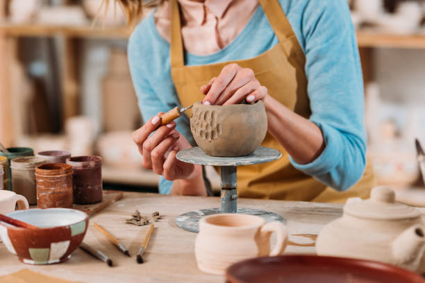 istock cropped view of potter in apron decorating ceramic bowl in workshop 1001338856
