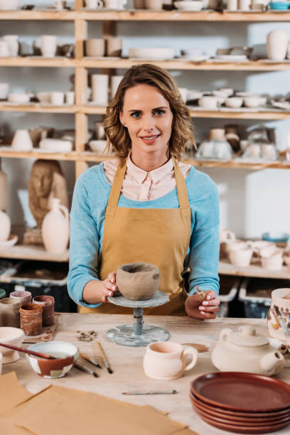 istock happy female potter decorating ceramic bowl in workshop 1001342092