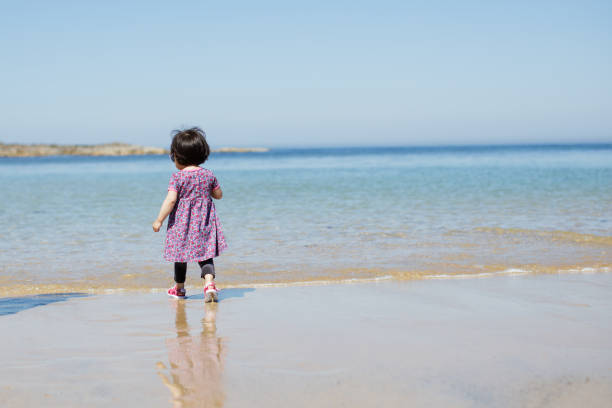 istock baby girl playing at summer beach 1001342454