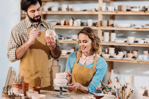 istock happy potters painting ceramic dishware in workshop 1001342498