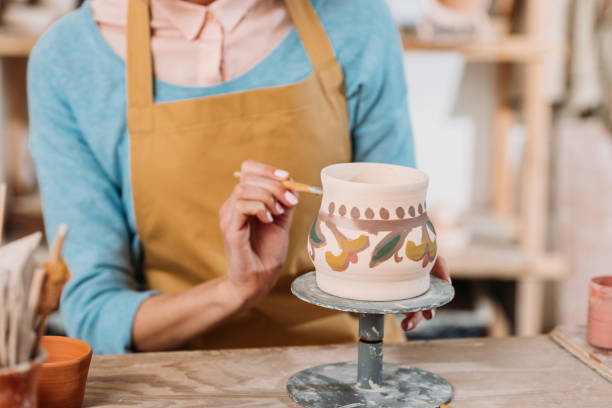 istock partial view of potter in apron painting traditional ceramic jug 1001345514