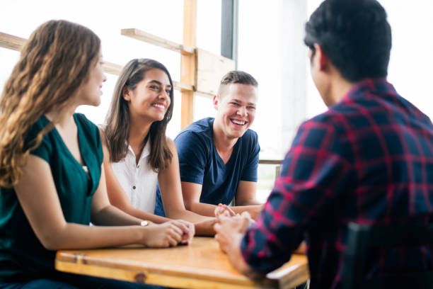 istock Group of friends sitting at table and laughing 1001346000