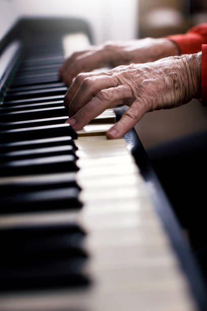 istock Wrinkled old hands playing the piano 1001350304