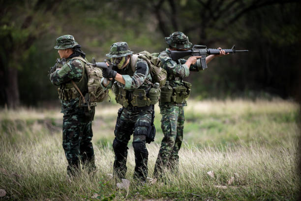 istock Squad of soldiers patrolling across the forest area. 1001353220