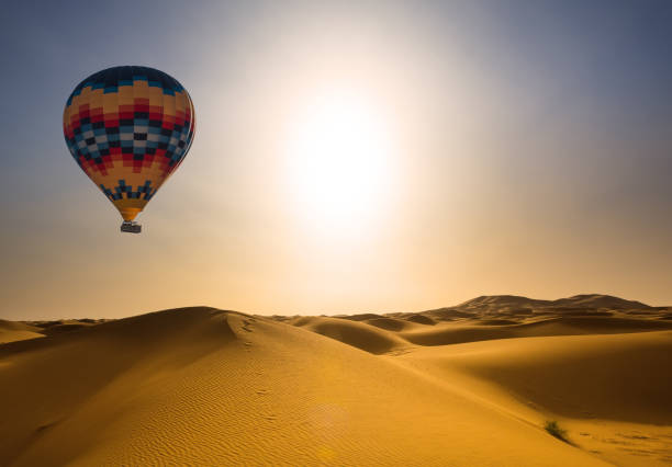 désert et hot air balloon paysage au lever du soleil - oasis sand sand dune desert photos et images de collection