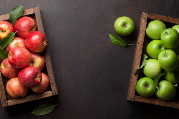 istock Green and red apples in wooden box 1001353334