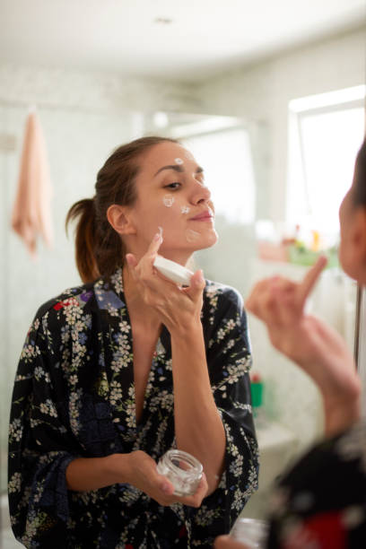 woman in the bathroom - moisturizer women cosmetics body imagens e fotografias de stock