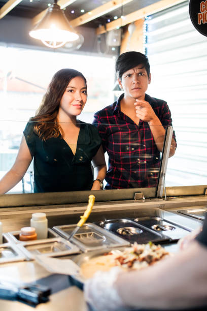 istock Two young people standing and choosing food at restaurant 1001353710