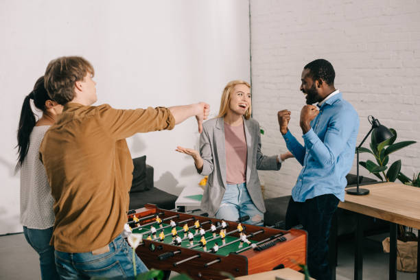 istock multiethnic businesspeople playing table football and doing different gestures in modern office 1001354502