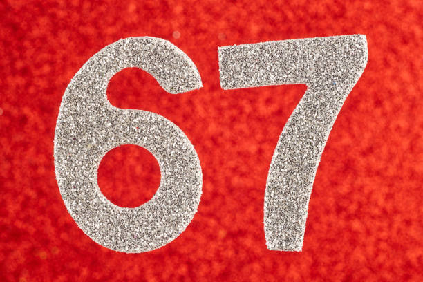 istock Number sixty-seven silver color over a red background. Anniversary 1001357974