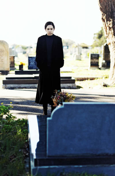 istock Woman in black walking through cemetery 1001358564