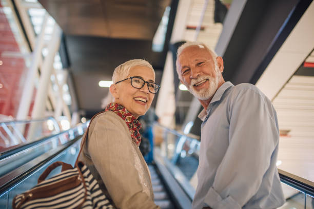 istock Smiling senior couple riding up the escalators 1001359234