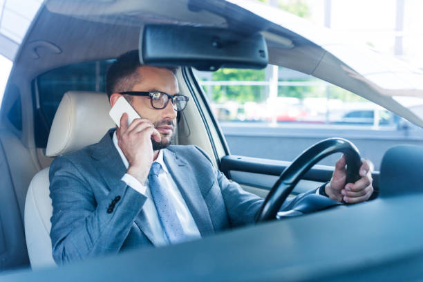 istock side view of businessman talking on smartphone while driving car 1001362970