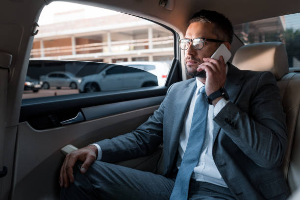 istock businessman talking on smartphone on backseat in car 1001363326