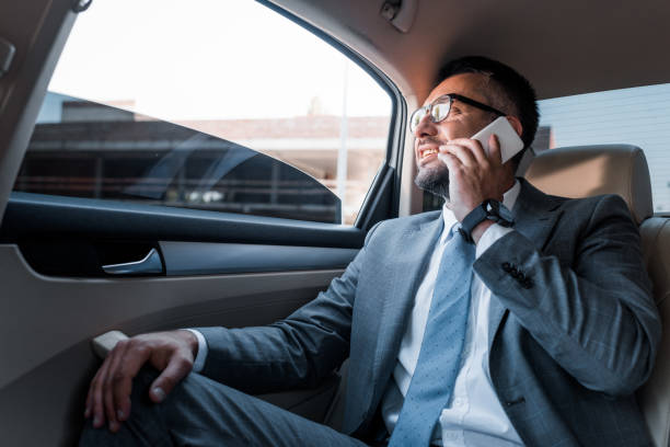 istock businessman talking on smartphone on backseat in car 1001363352