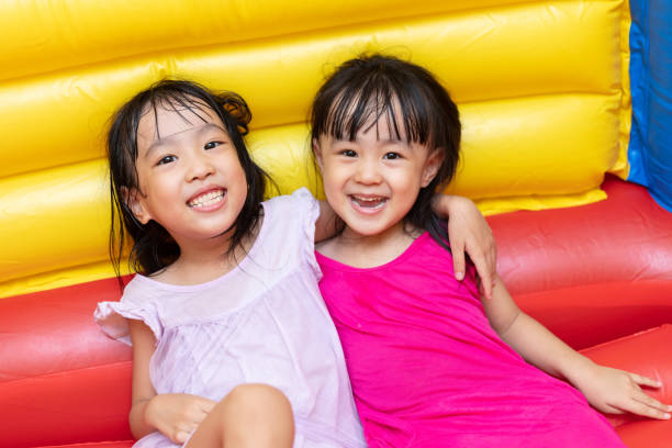 istock Asian Little Chinese sisters playing at inflatable castle 1001369894