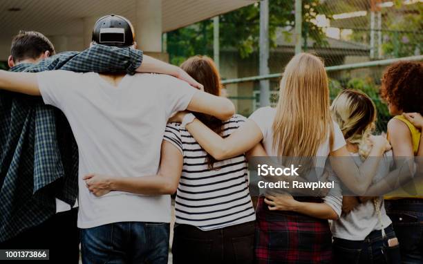 Sonriendo En Brazos De Amigos Adultos Jóvenes Felices Alrededor De Hombro Al Aire Libre Amistad Y Conexión Concepto Foto de stock y más banco de imágenes de Adolescente