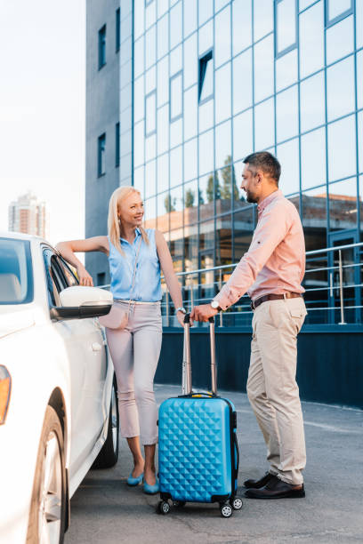 istock husband and wife with baggage standing at car on parking 1001378484