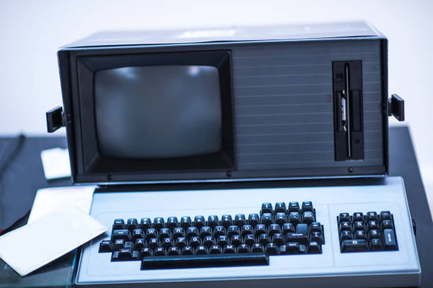 istock old and obsolete computer on old wood table with concrete wall background, vintage color tone 1001383336