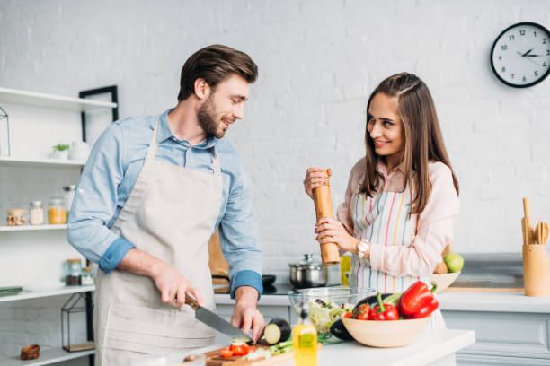 istock boyfriend cutting vegetables and girlfriend adding spices to salad in kitchen 1001386022