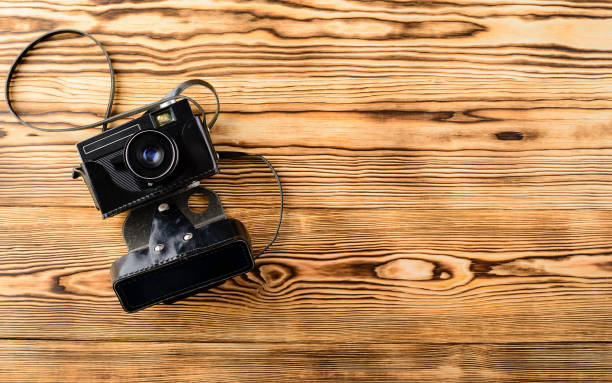 istock Old retro vintage old-fashioned camera in leather case on wooden 1001395392