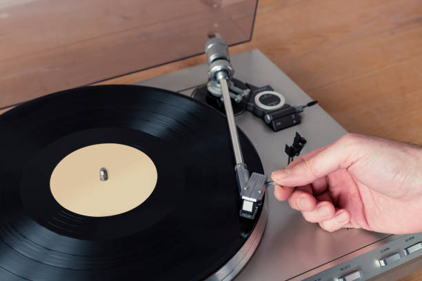istock Hand Placing Stylus of Record Player to a Spinning Vinyl 1001397716