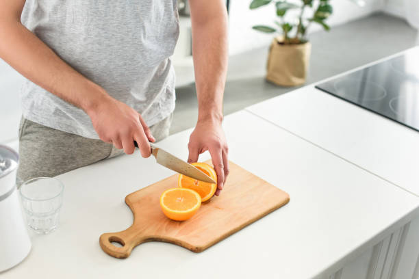 istock cropped image of man cutting oranges by knife on tabletop 1001401410
