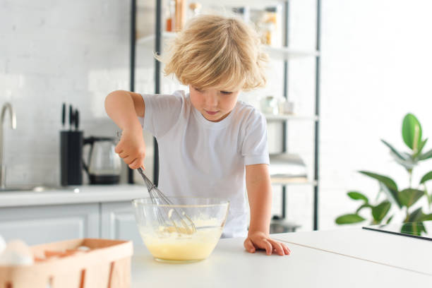istock little boy making dough by whisk on table at kitchen 1001401750