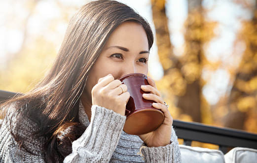 Shot of an attractive young woman having a relaxing coffee break on an autumn day in a garden