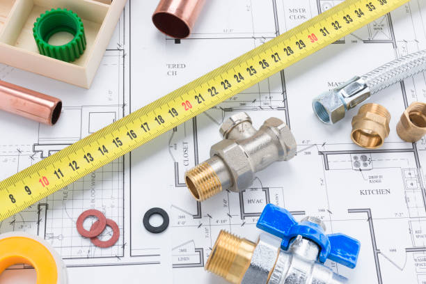 istock Valves, Pipe Fittings and Tape Measure on Building Plan Background 1001404984