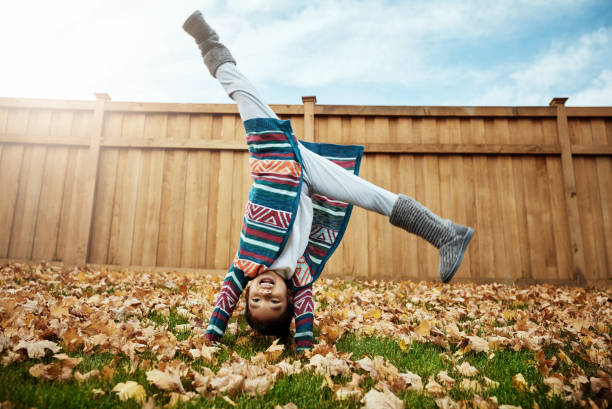 Goodbye summer, hello autumn Shot of an adorable little girl doing cartwheels an autumn day outdoors fall lawn stock pictures, royalty-free photos & images