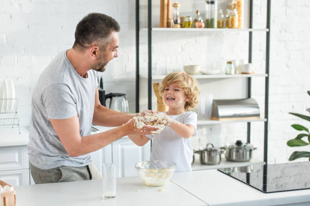 istock happy father and son having fun while making dough in bowl at kitchen 1001405422