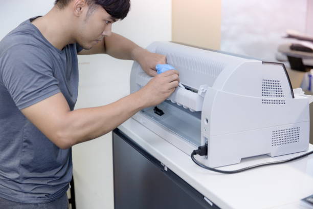 istock Male technician repairing a dot matrix printer on the white desk. 1001405886