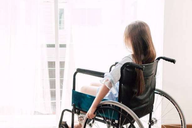 Little girl sitting on wheelchair in the hospital stock photo
