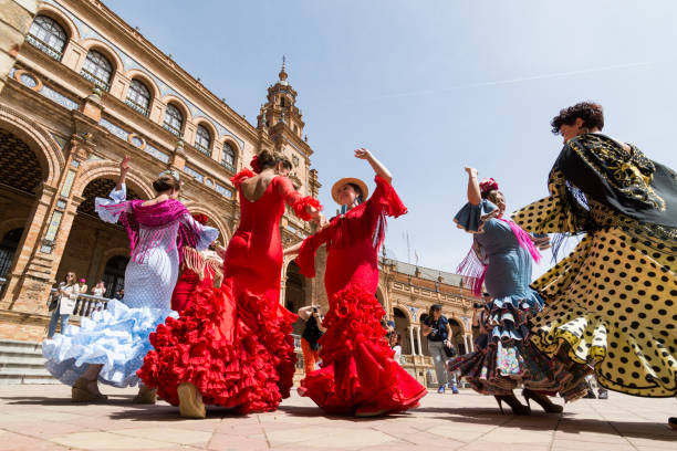 Young women dance flamenco on Plaza de Espana in Seville, Spain Seville, Spain - May 2017: Young women dance flamenco on Plaza de Espana during famous Feria festival spanish culture stock pictures, royalty-free photos & images