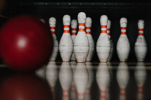 istock grungy bowling pins with red ball on foreground 1001413396