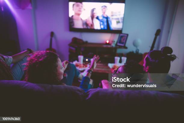 Multiethnic Teenage Friends Watching Tv Together At Hangout House Stock Photo - Download Image Now