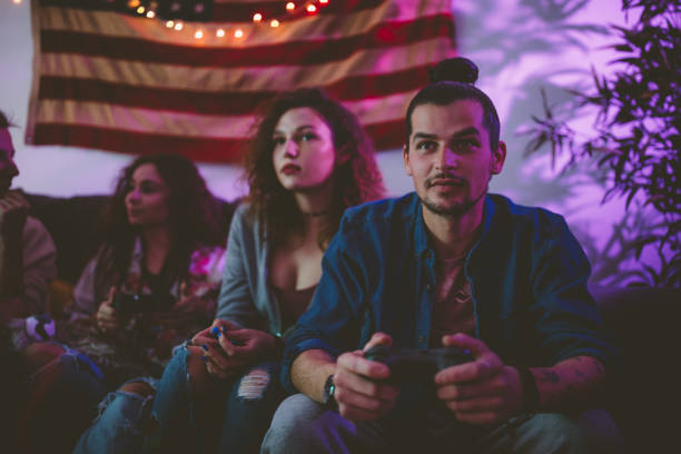 młodzi hipsterscy przyjaciele relaksują się i grają w gry wideo w domu - friendship video game young adult party zdjęcia i obrazy z banku zdjęć