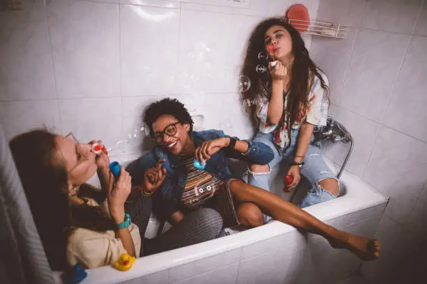 Photo of Young teenage girls being silly and having fun blowing bubbles
