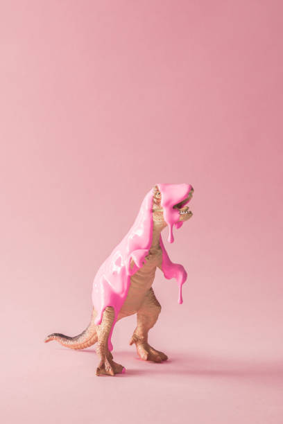 istock Pink paint dripping on dinosaur toy. Creative minimal concept. 1001419816